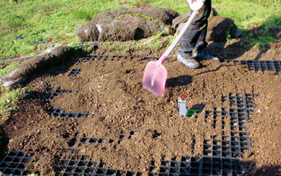 Mann verteilt Substrat auf den Rasterelementen