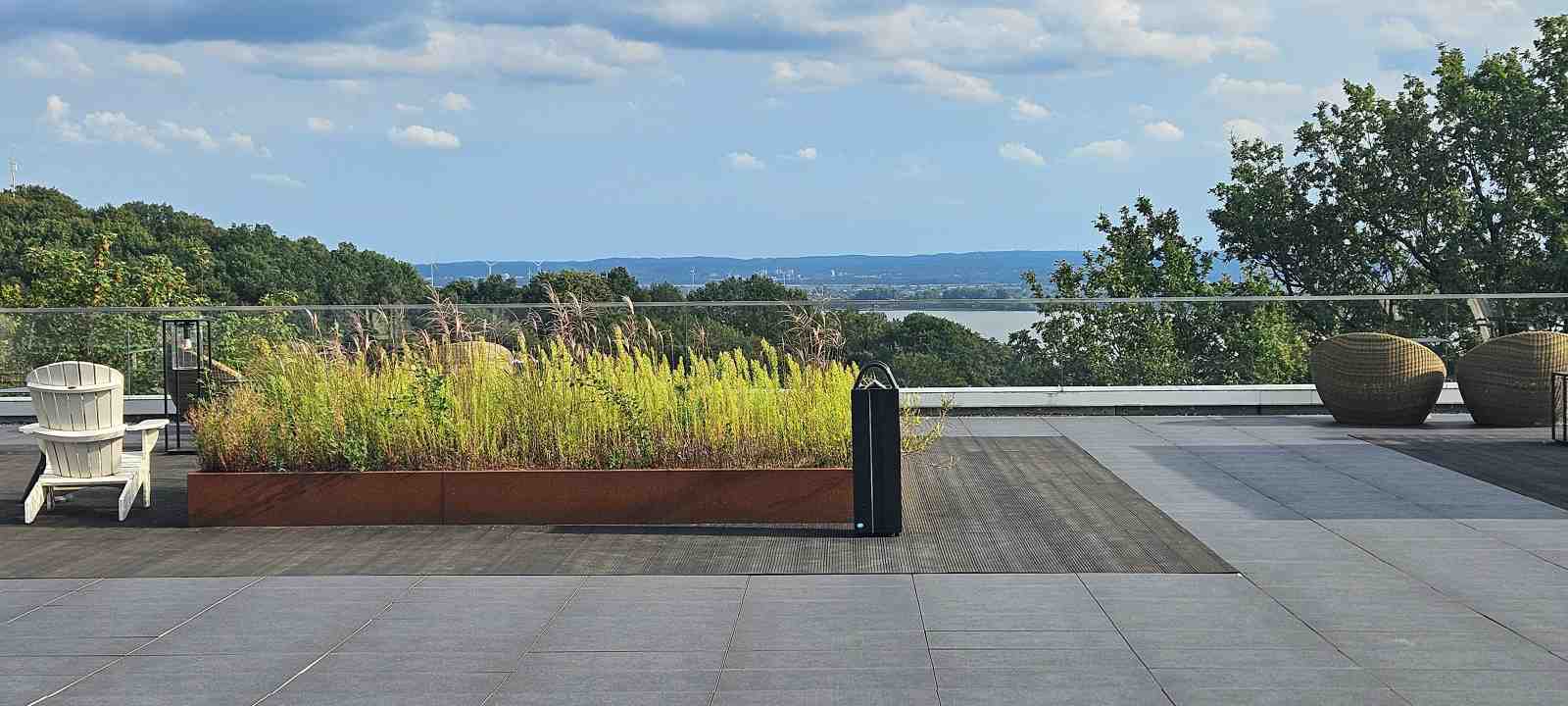 Dachterrasse mit Liegestuhl und Ziergräsern