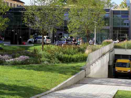 Lieferwagen fährt aus einer üppig begrünten Tiefgarage heraus