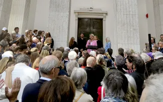 Sprecherin hält eine Rede vor einer Menschengruppe